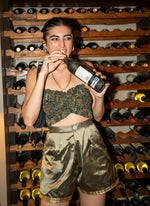 Perfect sustainable summer outfit. Upcycled gold raw silk shorts - high-waisted, wide-leg, and short-length. Styled with stretchy tube top. Wine not included!