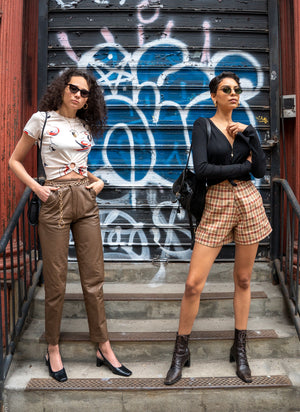 
                  
                    load image into gallery viewer, Two models in sustainable clothing (made by girl of the earth). One wears a pair of the timeless amsterdam shorts (high-waisted, wide-leg, and checkered), and the other wears a t-shirt. All clothing is upcyled out of 1970s vintage fabric.
                  
                