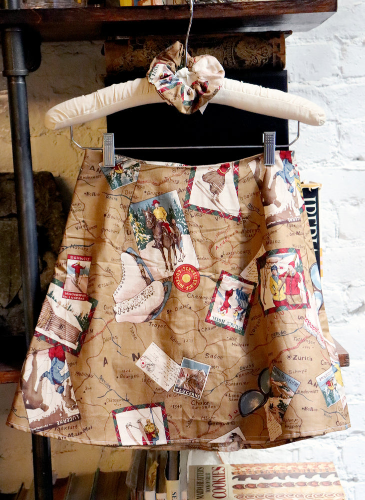 
                  
                    load image into gallery viewer, Ski-postcard-printed high-waisted A-line mini skirt. Sustainably upcycled using vintage fabric. Made locally in NY USA.
                  
                
