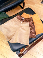 Perfect sustainable spring outfit. Upcycled gold raw silk shorts - high-waisted, wide-leg, and short-length. Styled on blonde model with black silk cami top and polka dot tights..